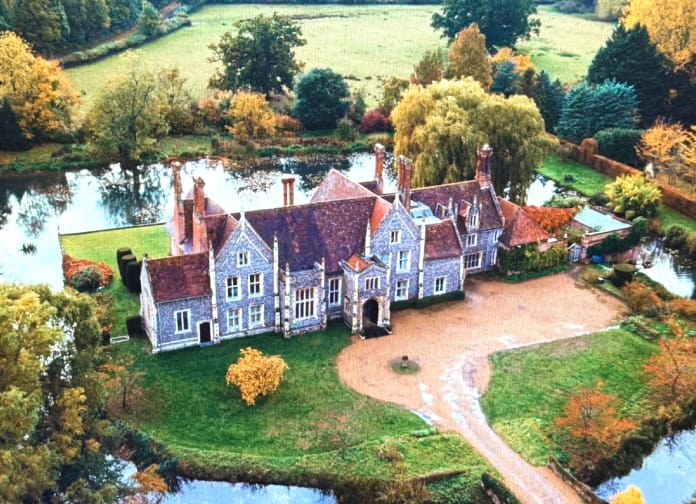 Luchtfoto van het landhuis in de film Blackwater Lane op Netflix, omgeven door water en herfstkleuren. Dit landhuis speelt een centrale rol in het verhaal.